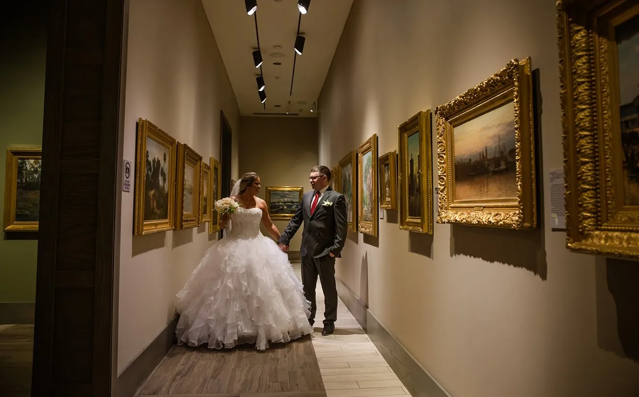Haley and Matt walking hand in hand through the hall of paintings