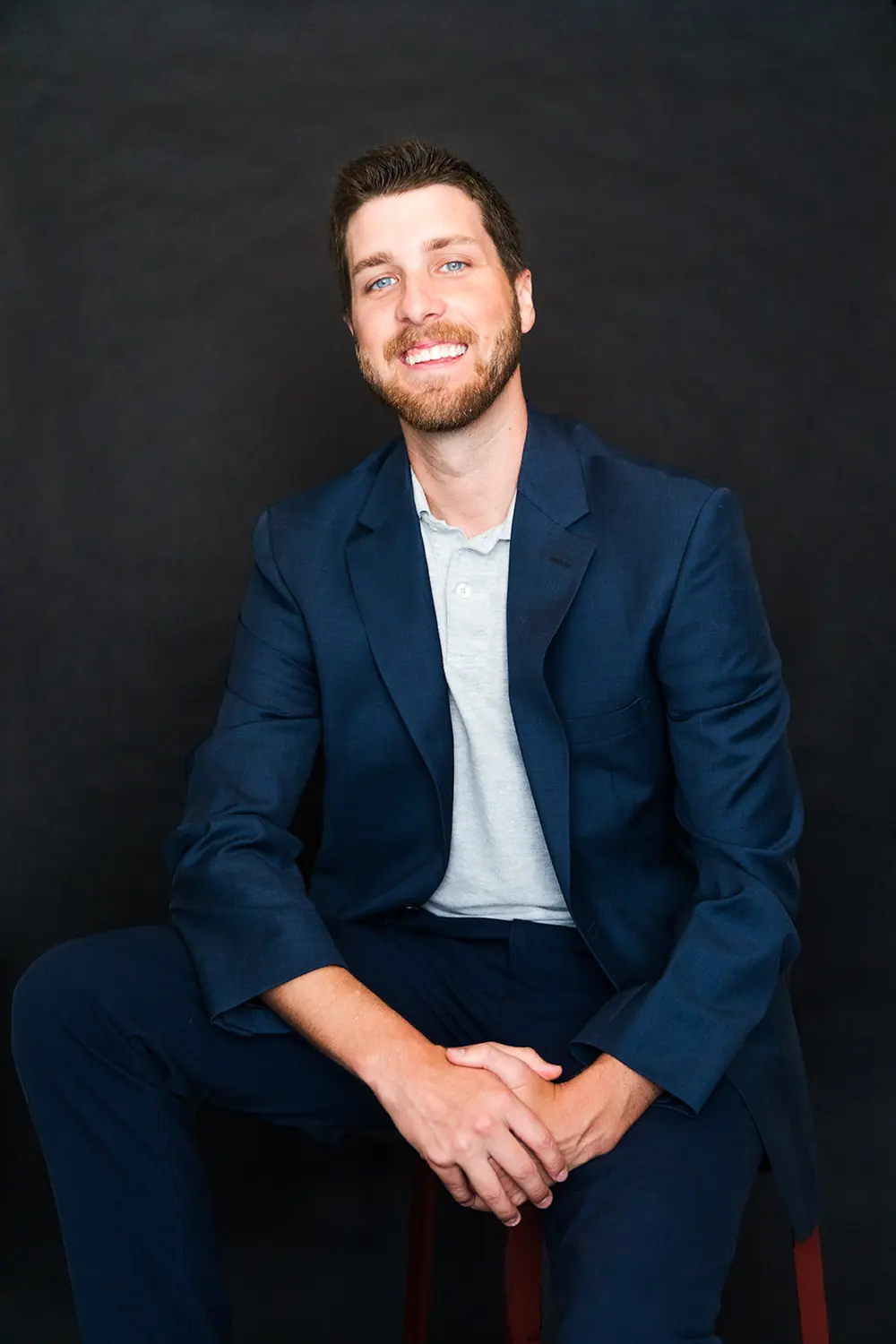 Professional branding portrait of a business founder photographed on a dark studio backdrop