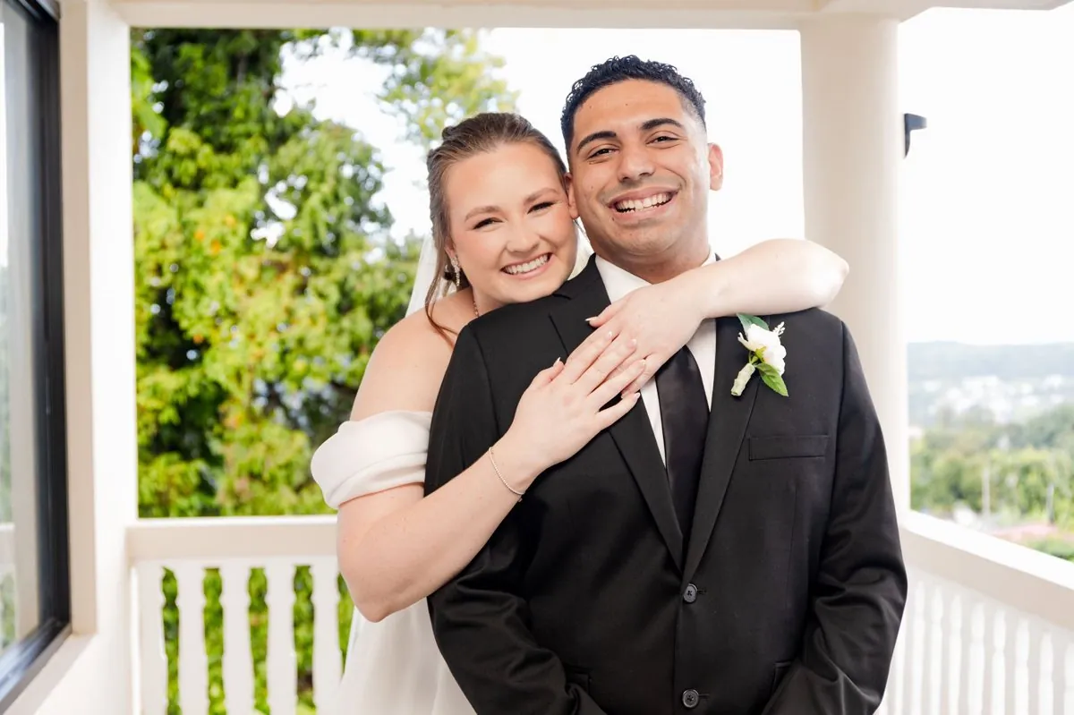 Victoria and Jose embracing on a balcony above the Puerto Rico rainforest