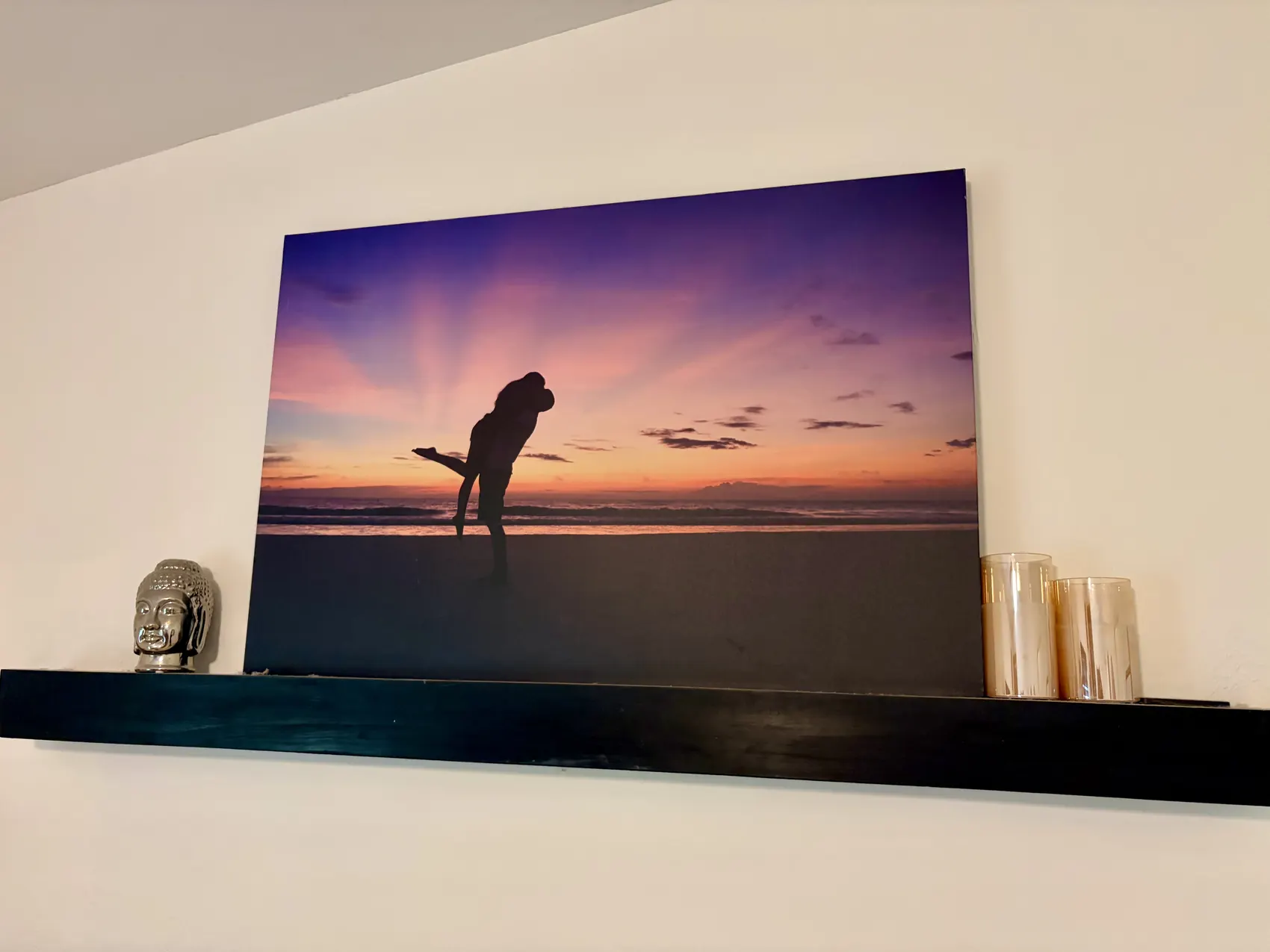 A couple's sunset photograph printed on metal and displayed on a shelf at home