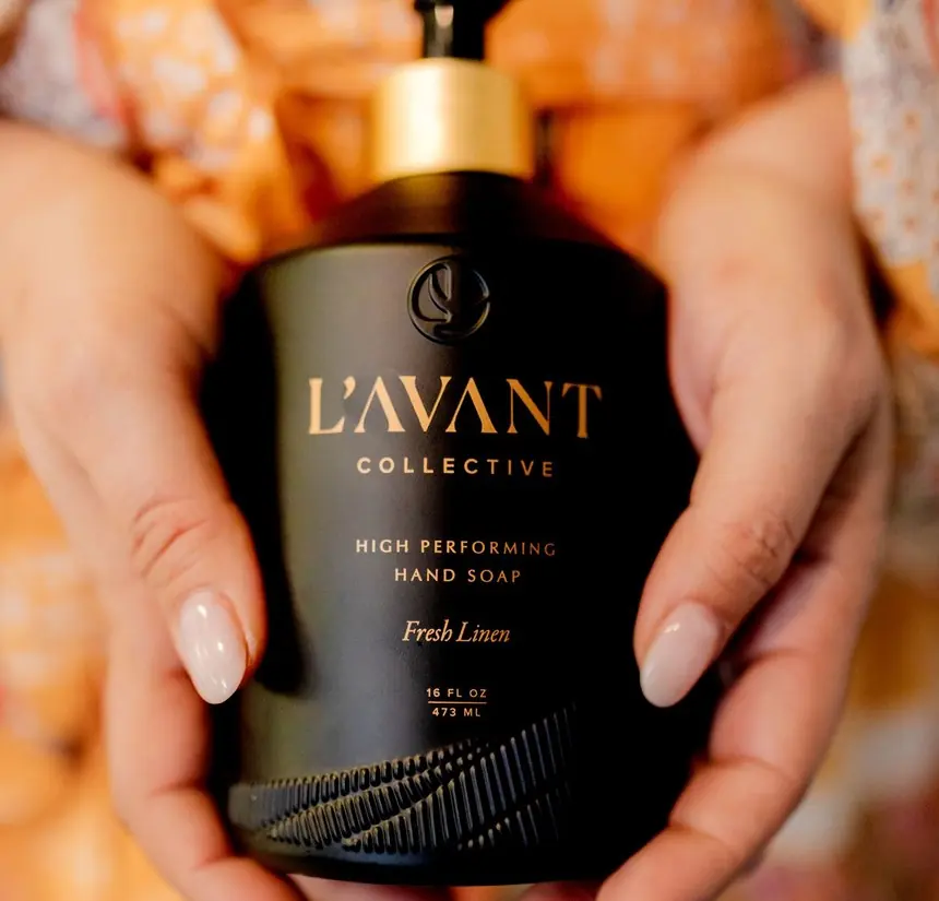 A branded hand soap bottle held in a client's hands