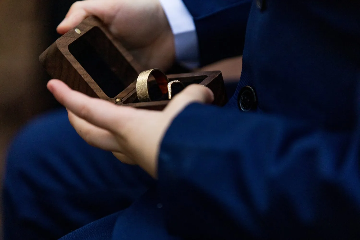 The ring bearer carefully holding the rings