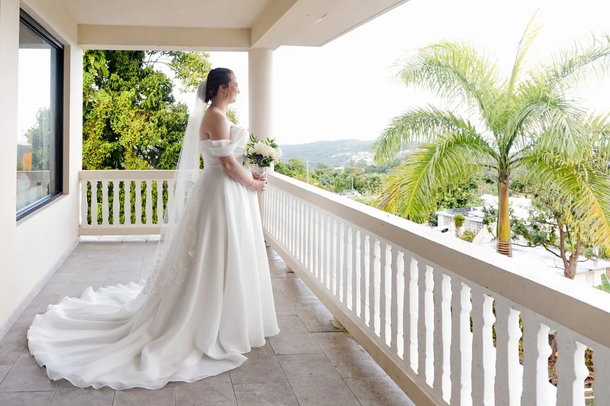 The bride looking out over the palms and rainforest from the balcony