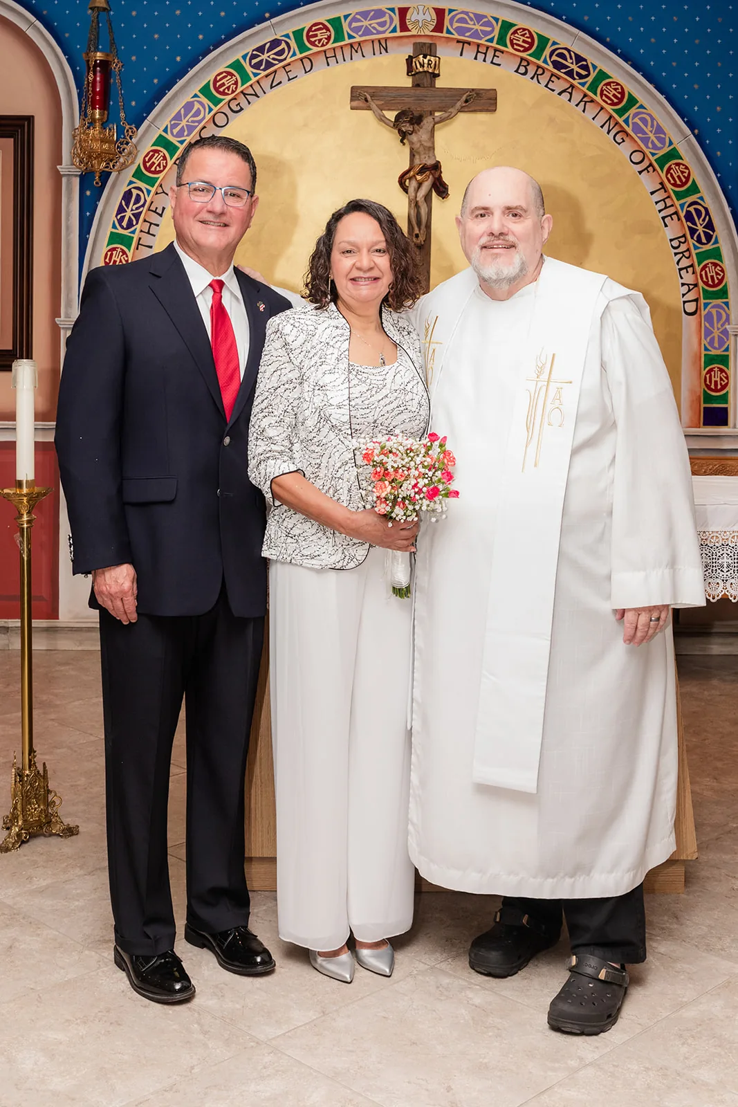 A couple with their officiant after renewing their vows
