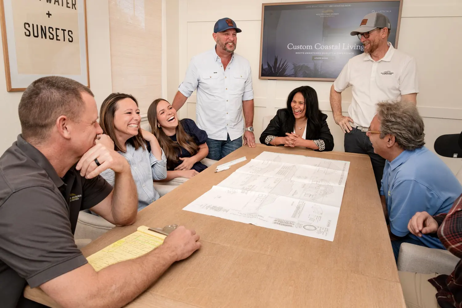 A team laughing together during a headshot and branding session at Saltwater Homes