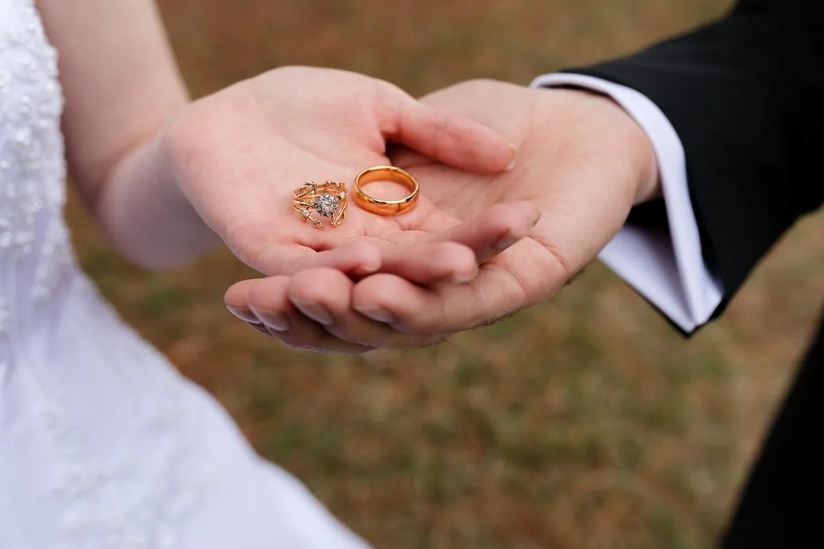 Wedding rings cupped in the couple's hands