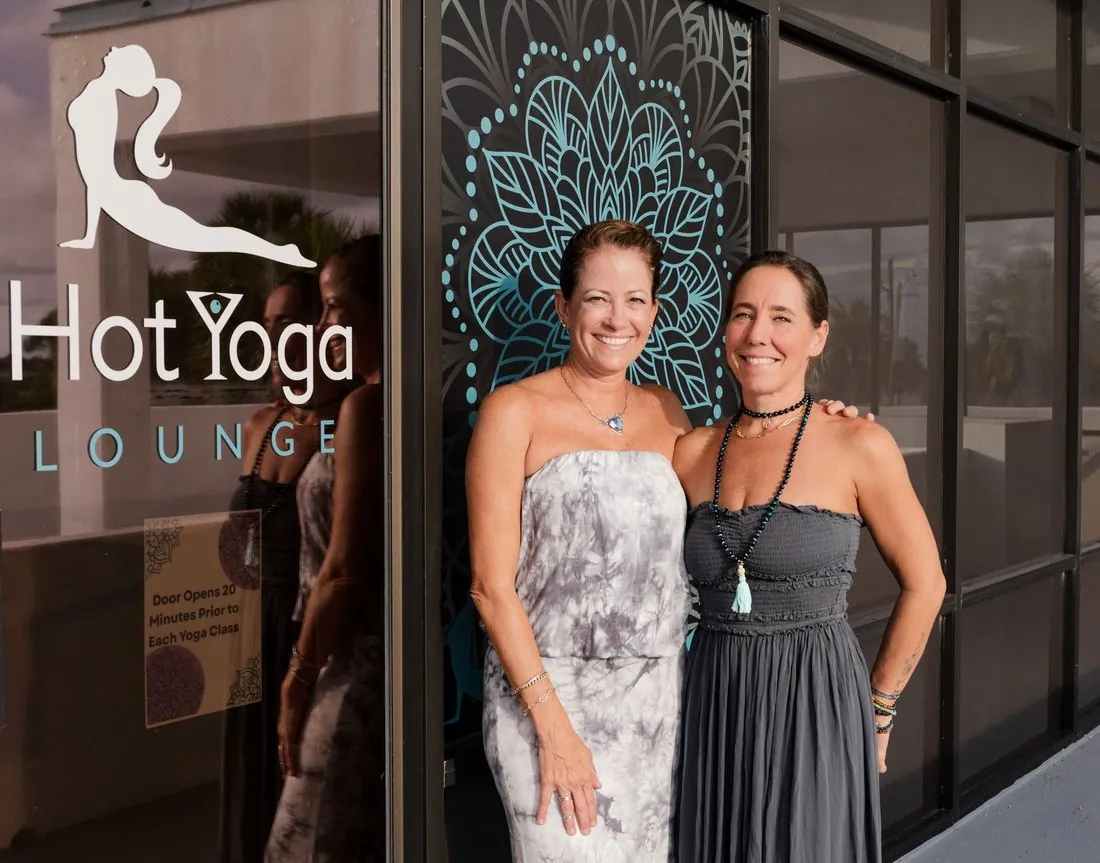 Two founders in front of their Hot Yoga Lounge studio
