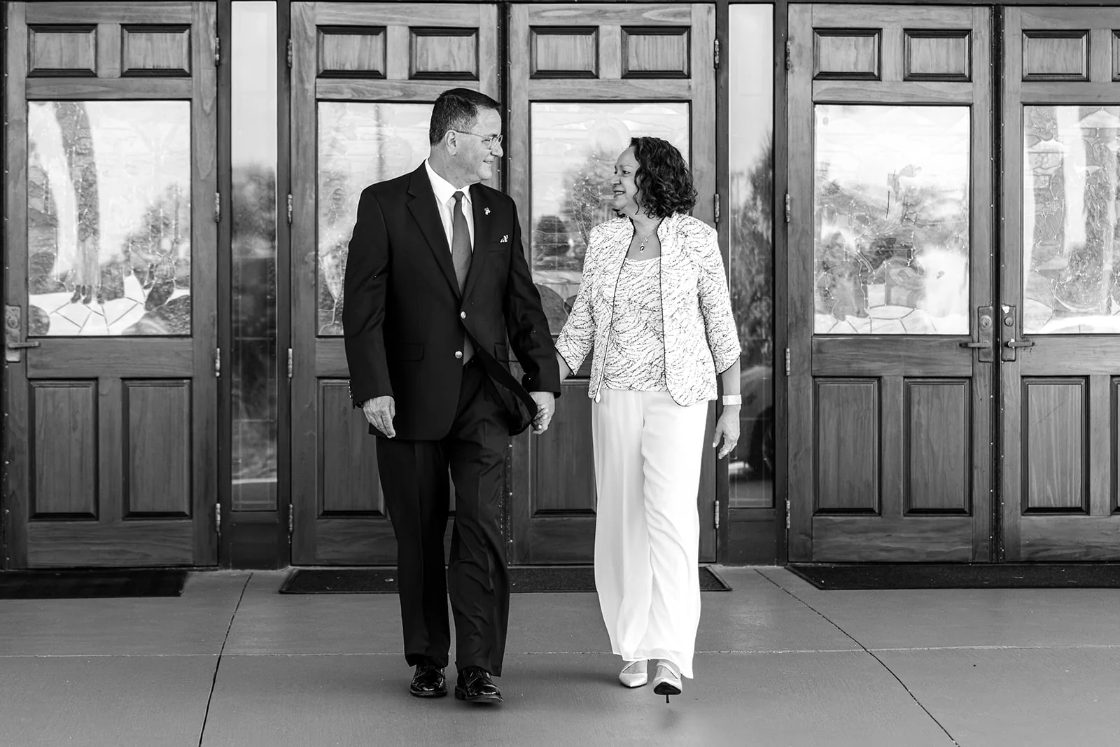 A couple walking hand in hand after their church vow renewal