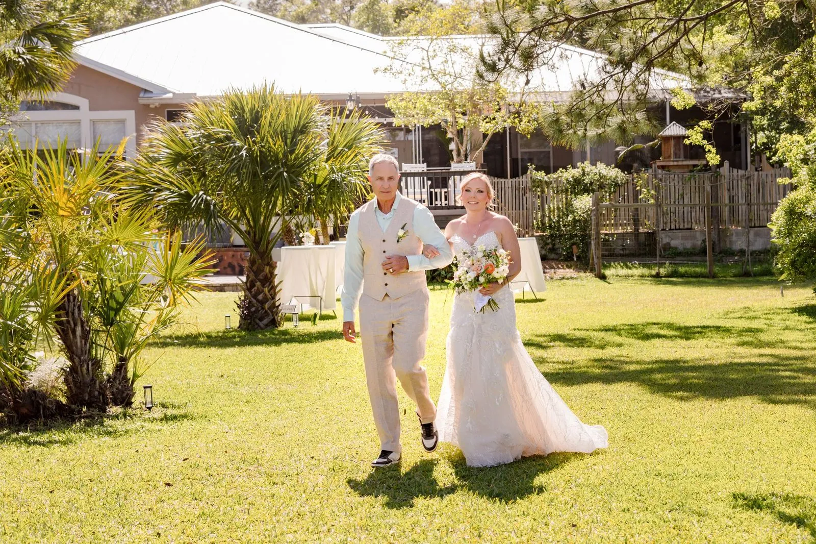 Bride walked down a grass aisle by her father at a backyard wedding in Northeast Florida