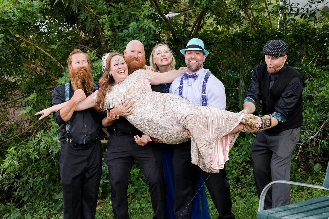 The wedding party lifting the bride in celebration